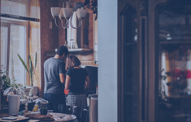 Two people standing in the kitchen